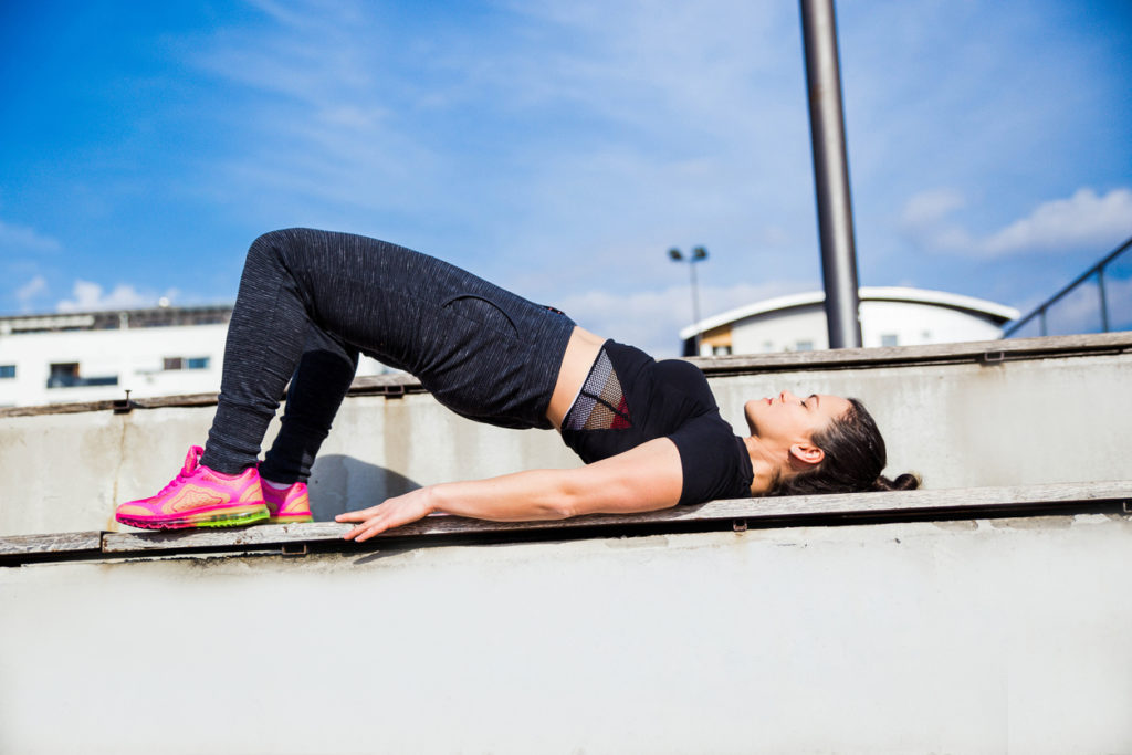 woman doing bridge stretch outside
