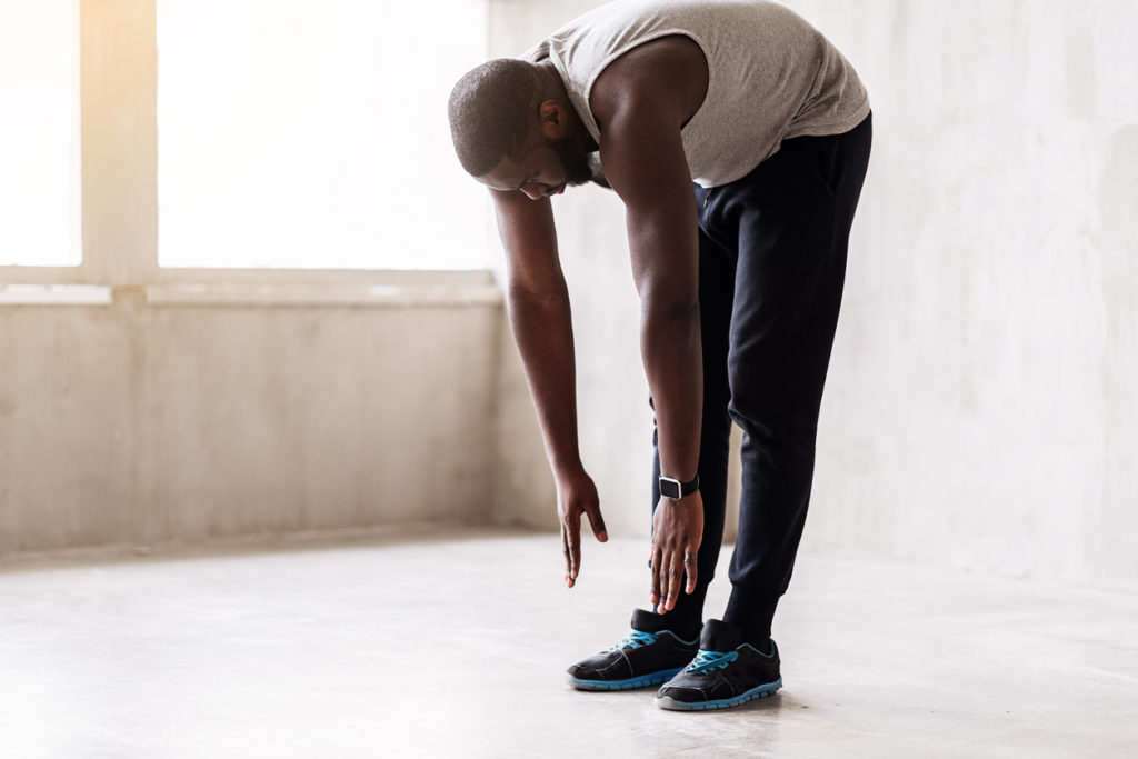 Man doing standing forward bend stretch
