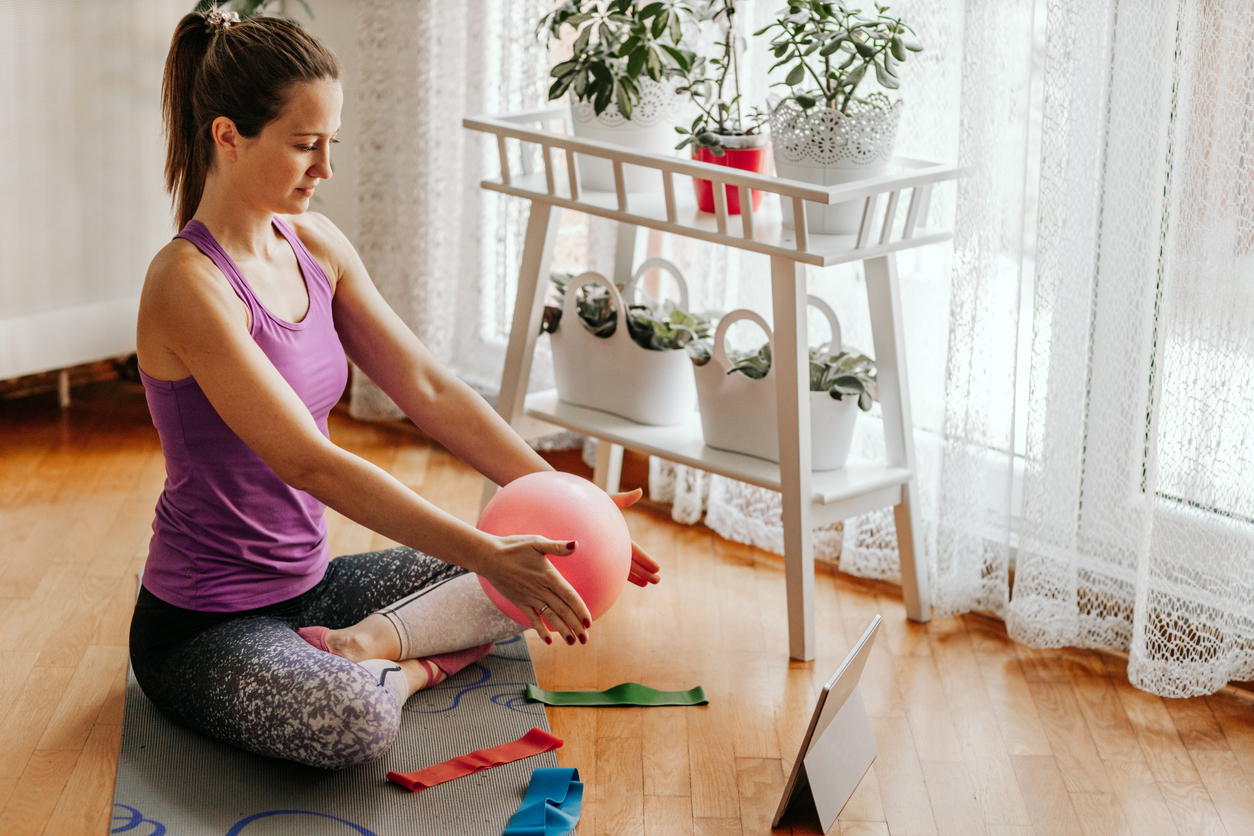 woman holding small ball while doing physical therapy