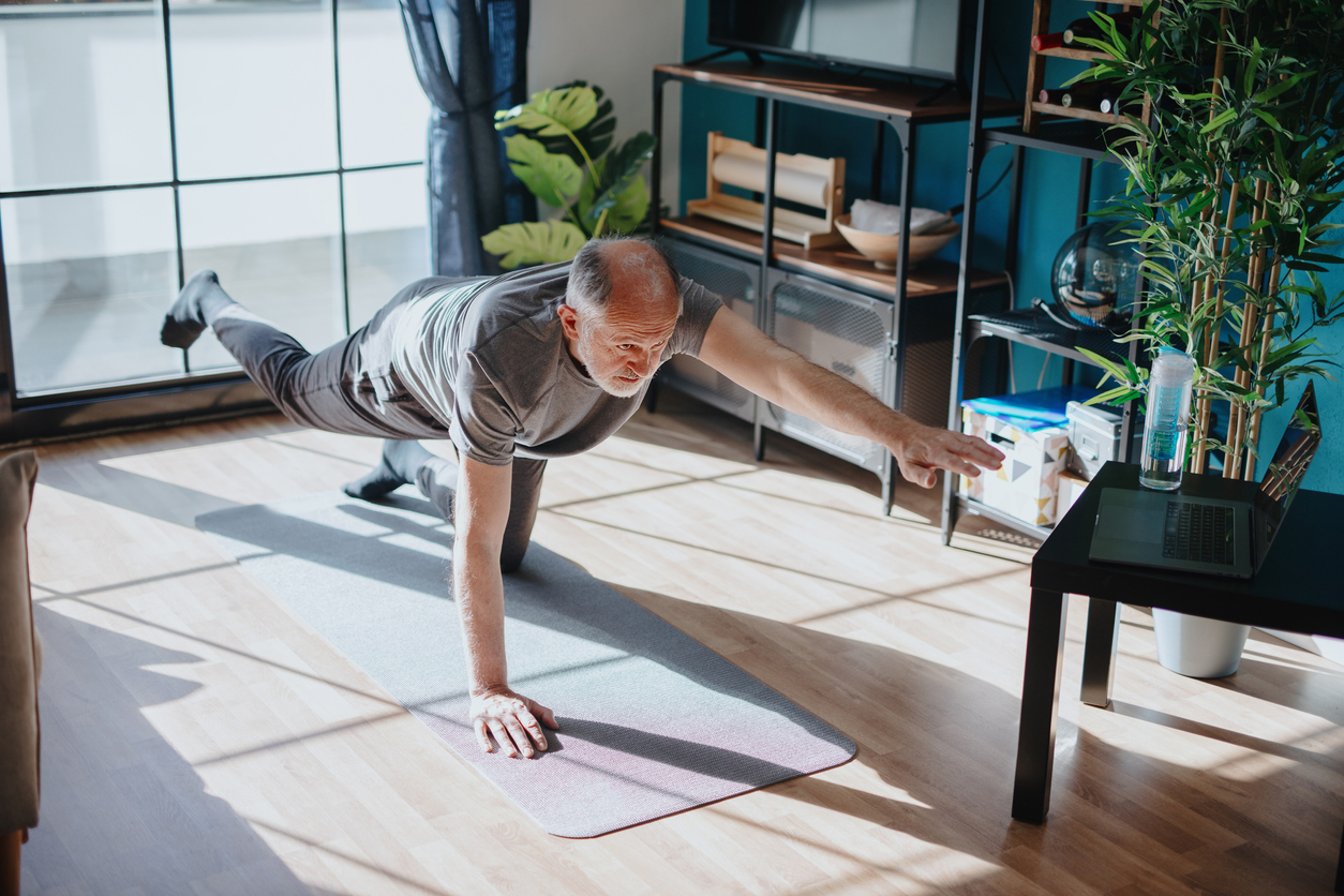 senior man stretching in his living room