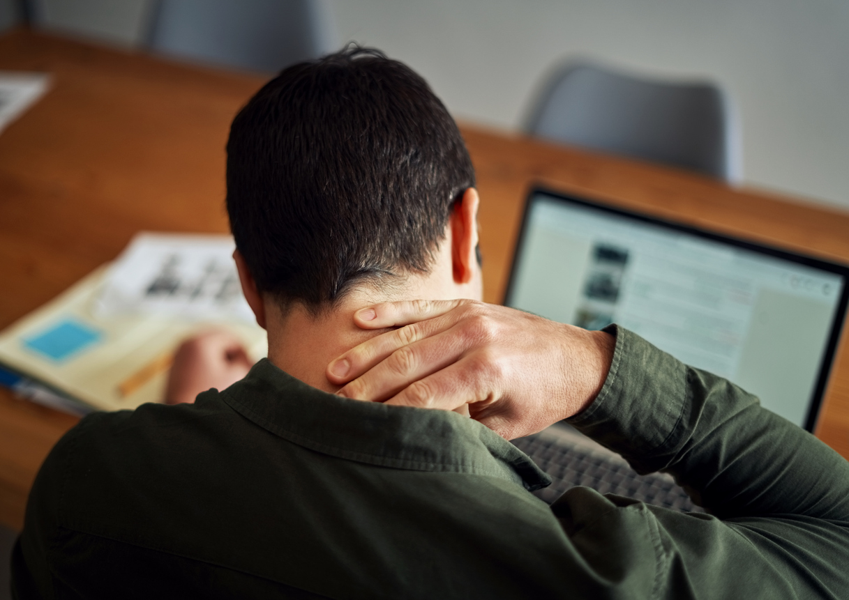 man suffering from neck pain