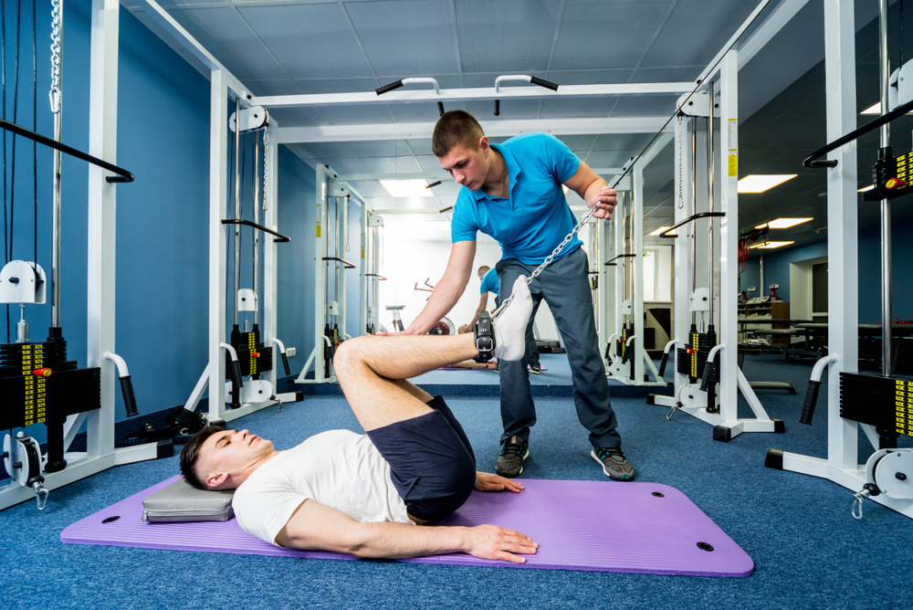 man exercising with physical therapist